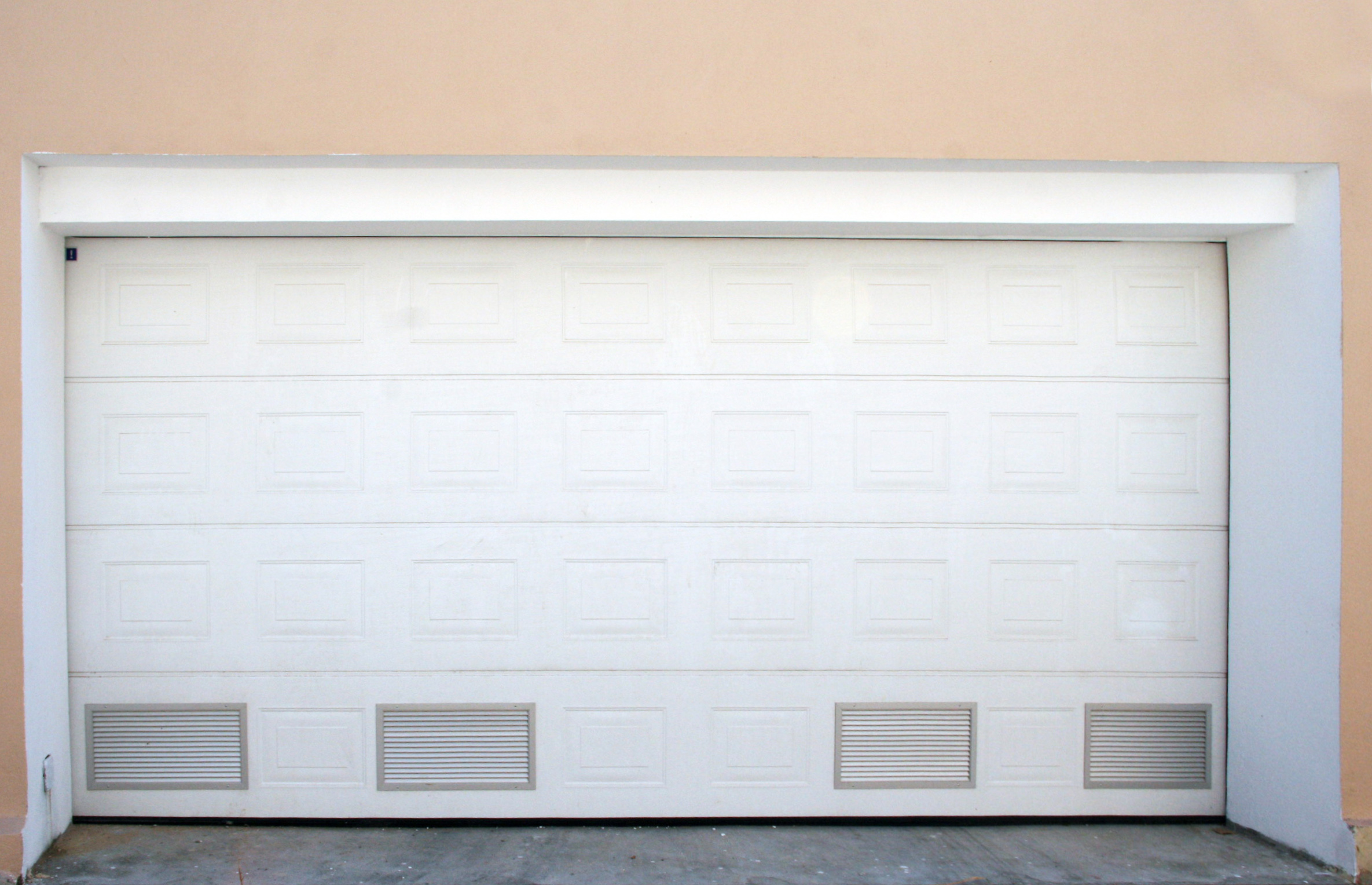 Porte sectionnelle d’habitat à cassettes et grilles d’aération.