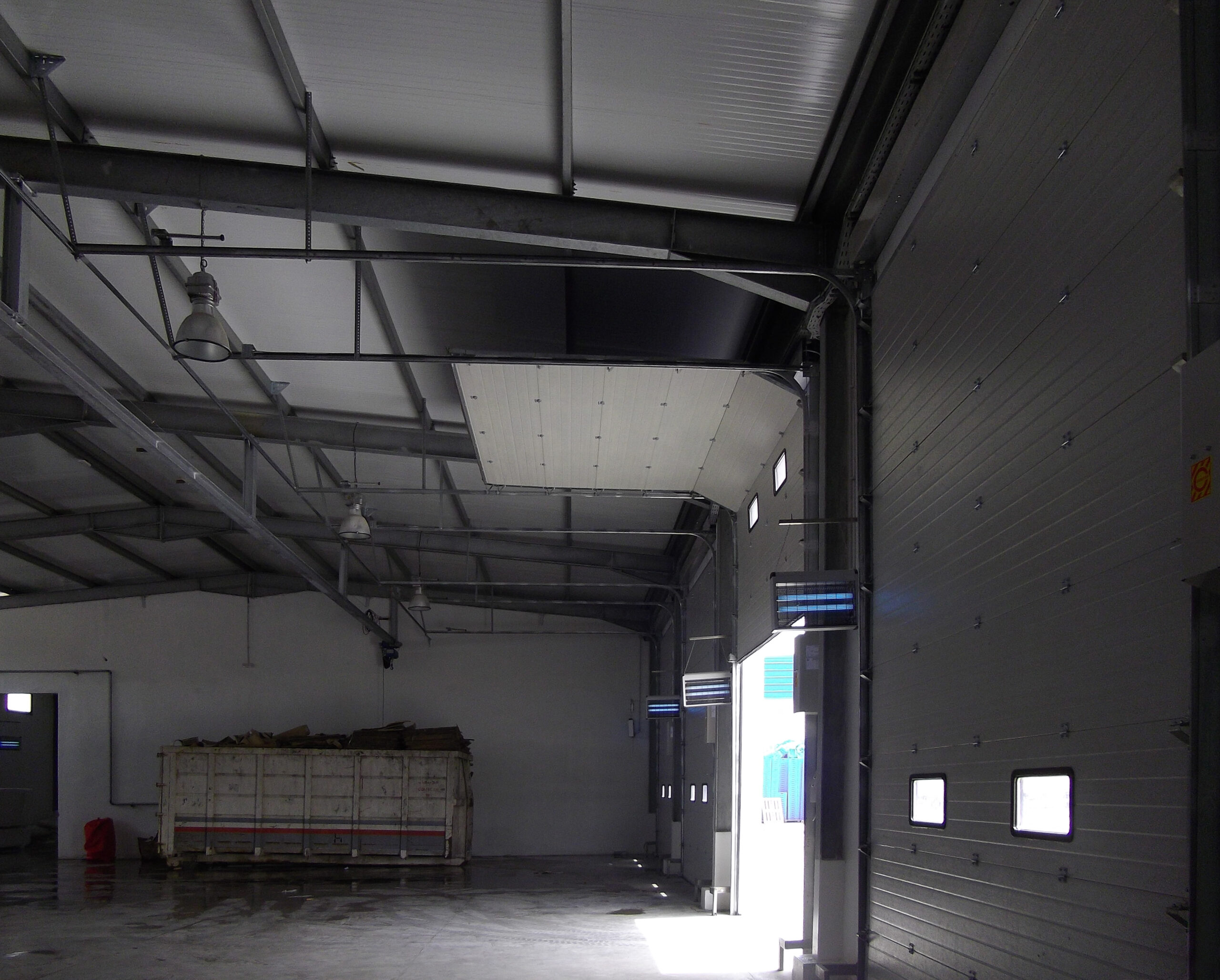 Porte sectionnelle industrielle avec hublots couleur blanche.