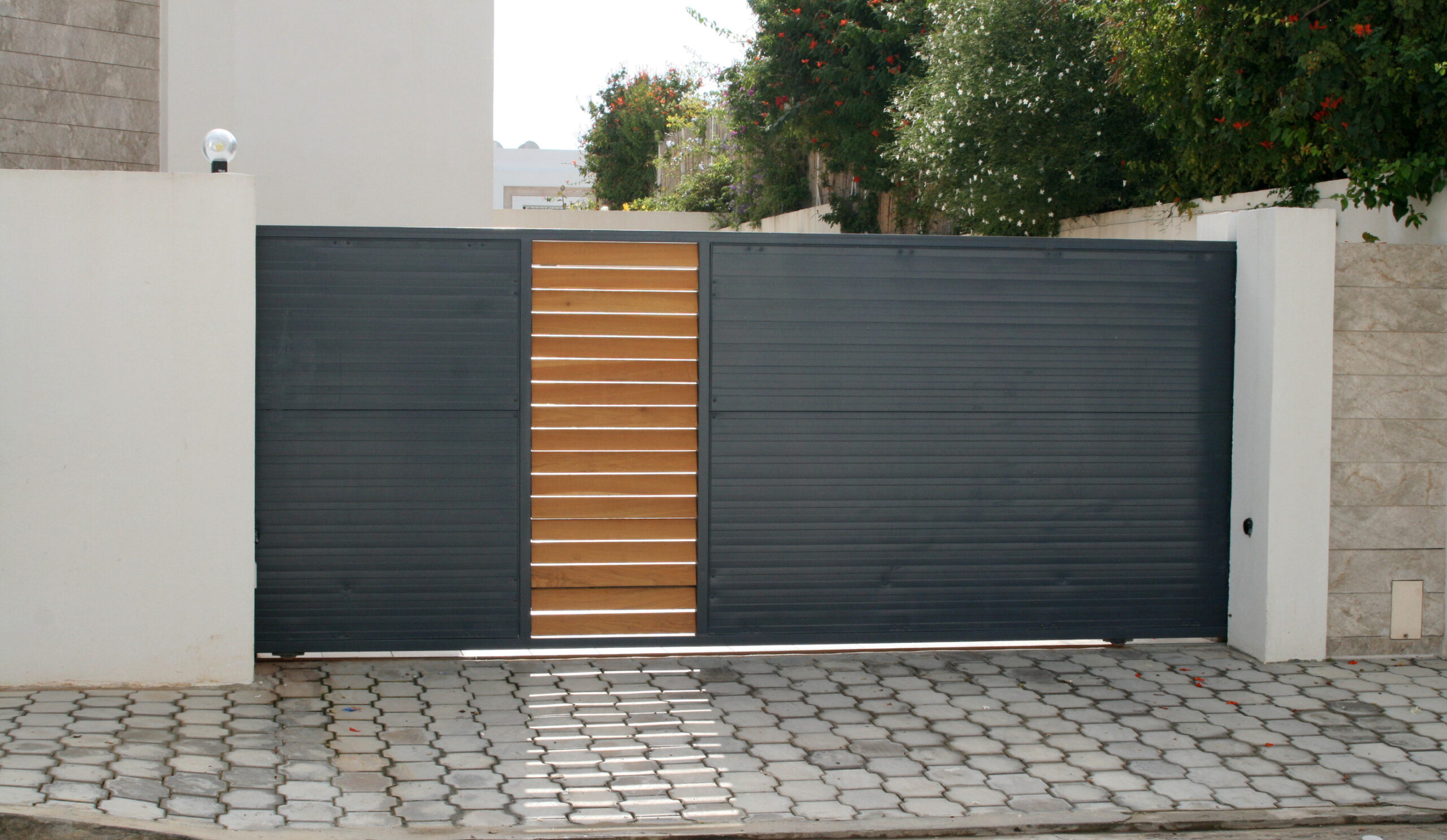 Porte coulissante en tôle nervurée sens horizontal incrustée partie en bois motorisée. Porte coulissante en tôle nervurée sens horizontal incrustée partie en bois motorisée.