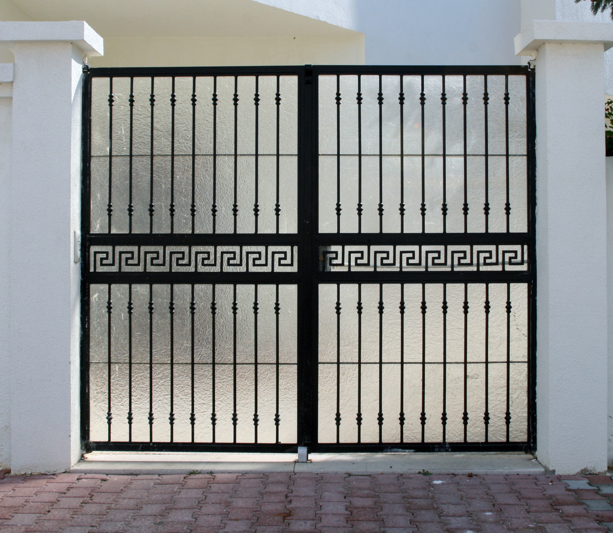 Porte battante à deux vantaux en fer forgé habillage plexi, fixation avec pivots. Porte battante à deux vantaux en fer forgé habillage plexi, fixation avec pivots.