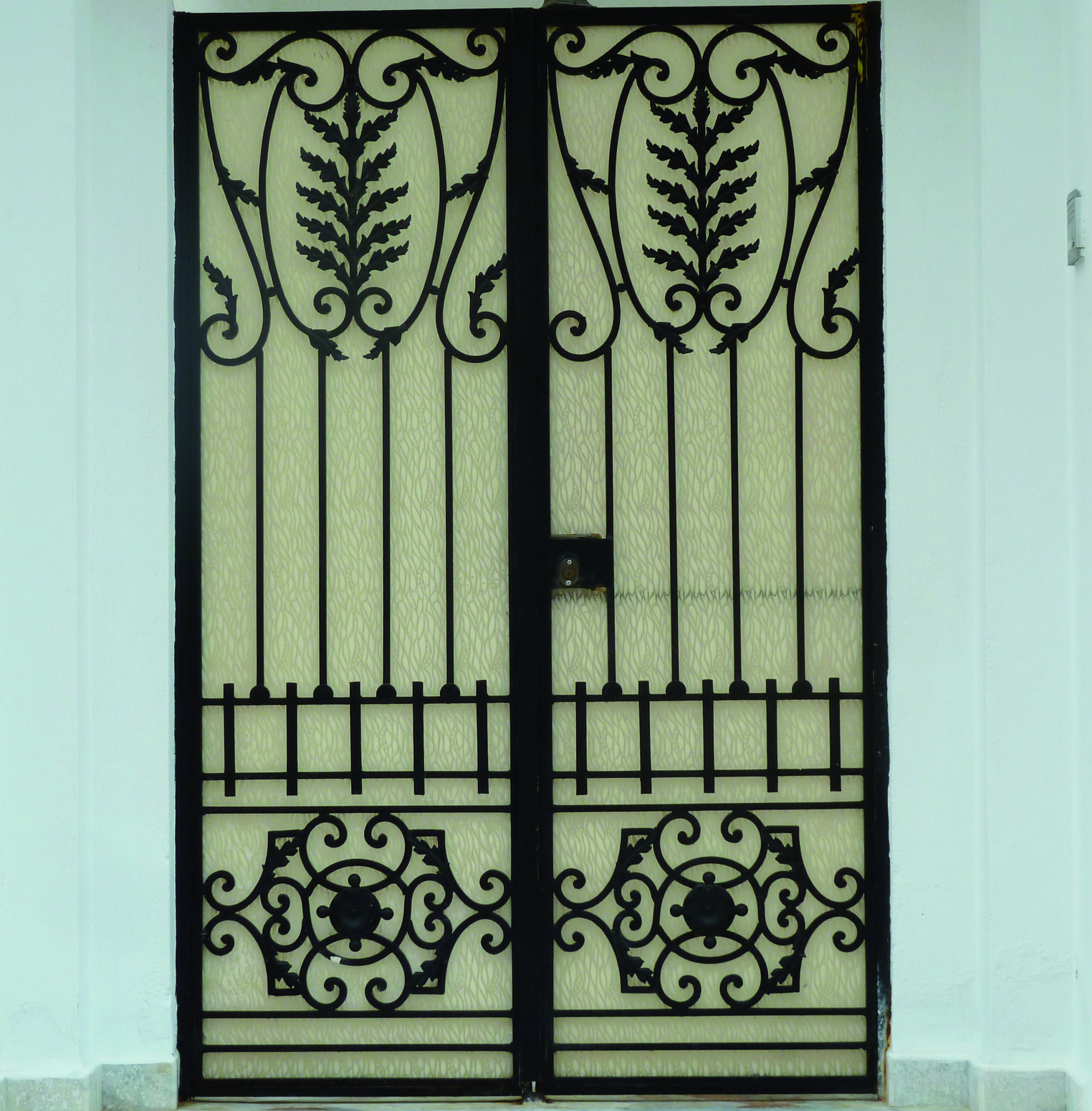 Porte battante à deux vantaux en fer forgé avec serrure électrique. Porte battante à deux vantaux en fer forgé avec serrure électrique.