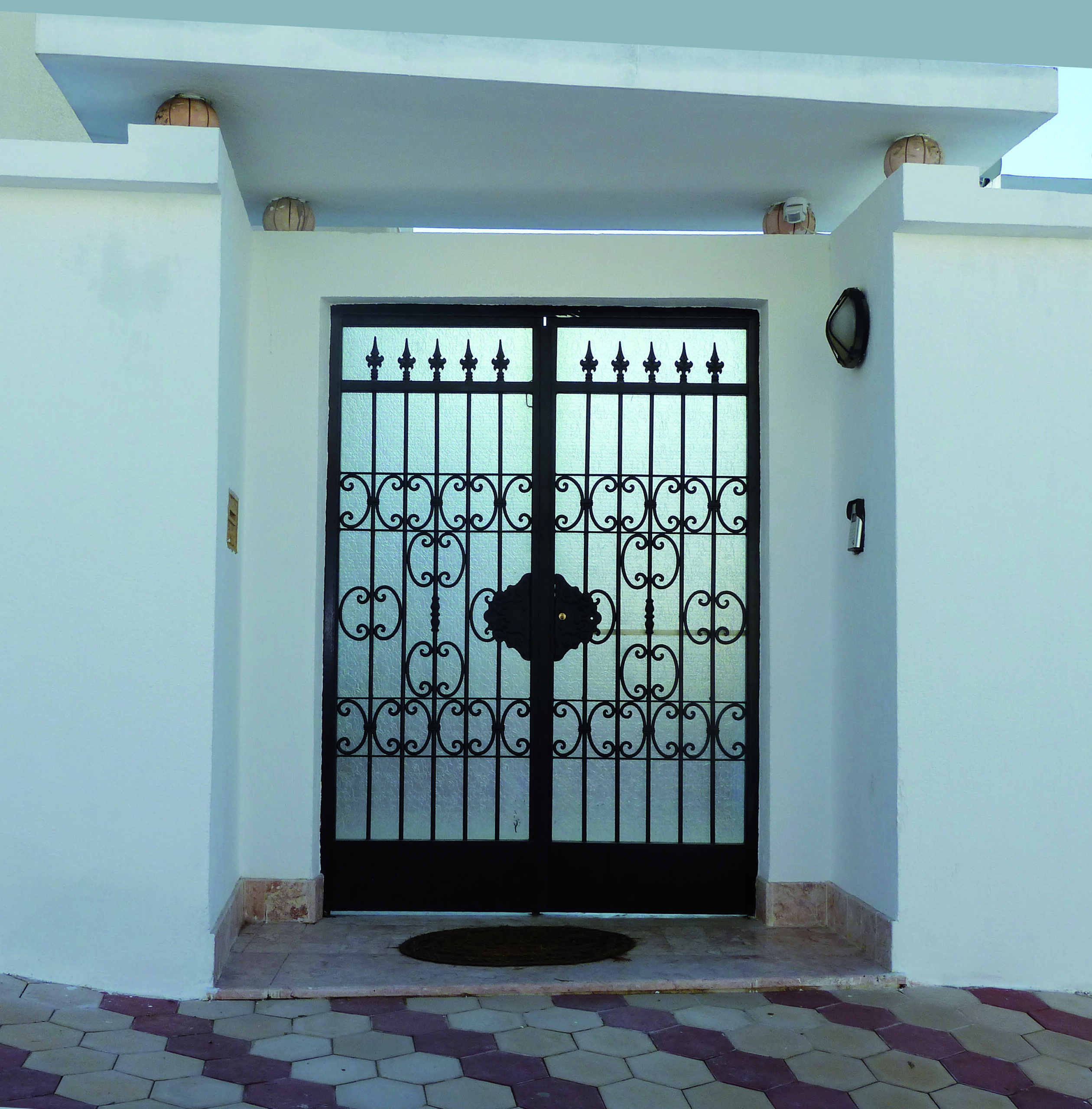 Porte battante à deux vantaux en fer forgé avec serrure électrique. Porte battante à deux vantaux en fer forgé avec serrure électrique.