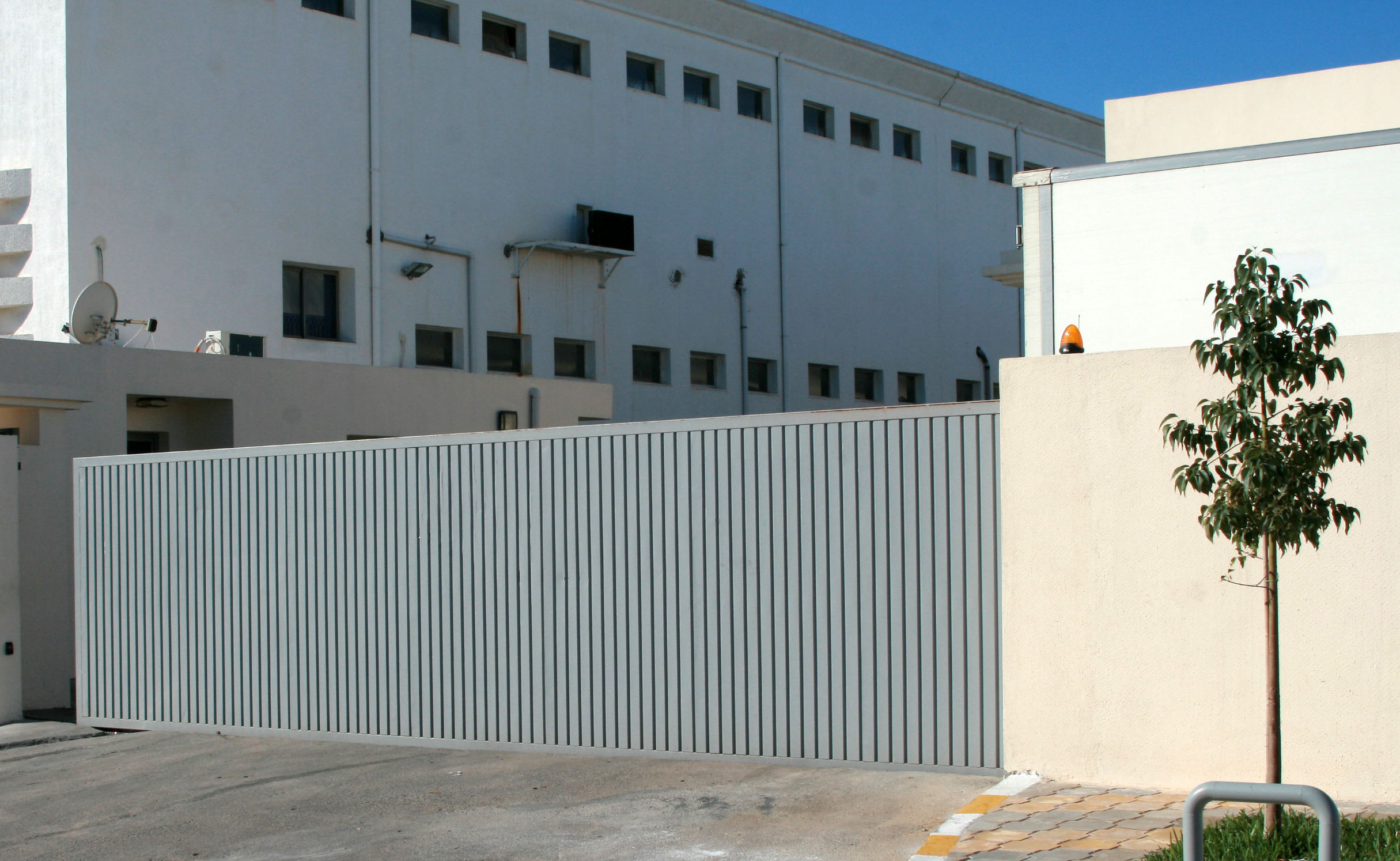 Porte coulissante industrielle motorisée en tôle nervurée simple paroi. Porte coulissante industrielle motorisée en tôle nervurée simple paroi.